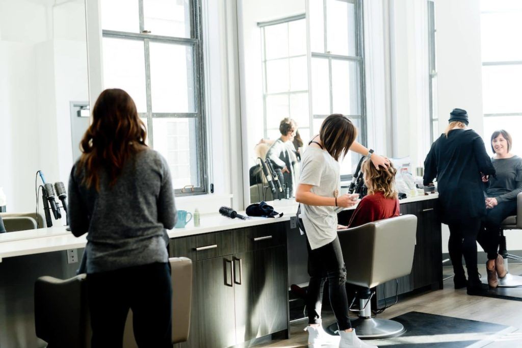 Coiffeuse entrain d'exercer dans un salon de coiffure